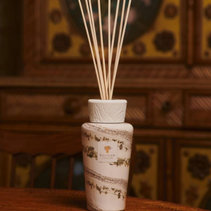 Difusor Baobab Sand Siloli Este difusor em vidro soprado à mão, gravado pelos artesãos em tons quentes de bege e castanho, revela um carácter naturalmente sofisticado e envolvente. A fragrância amadeirada do cedro e da fava tonka transporta-nos para um ambiente de clima equatorial, suavemente iluminado por um toque de limão verde que acrescenta uma frescura invulgar e equilibrada ao espaço.